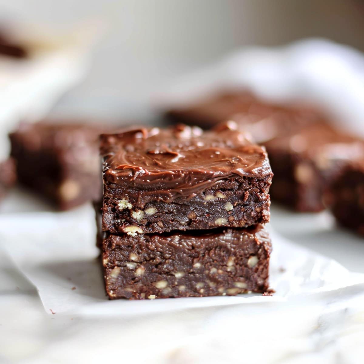 A decadent stack of no-bake brownies topped with a drizzle of chocolate sauce