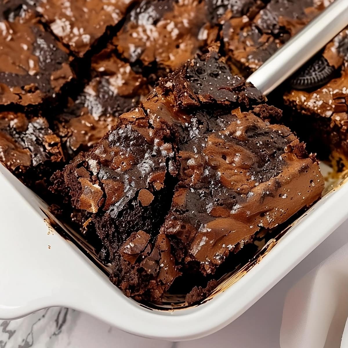 Sliced Oreo dump cake in a white baking dish.