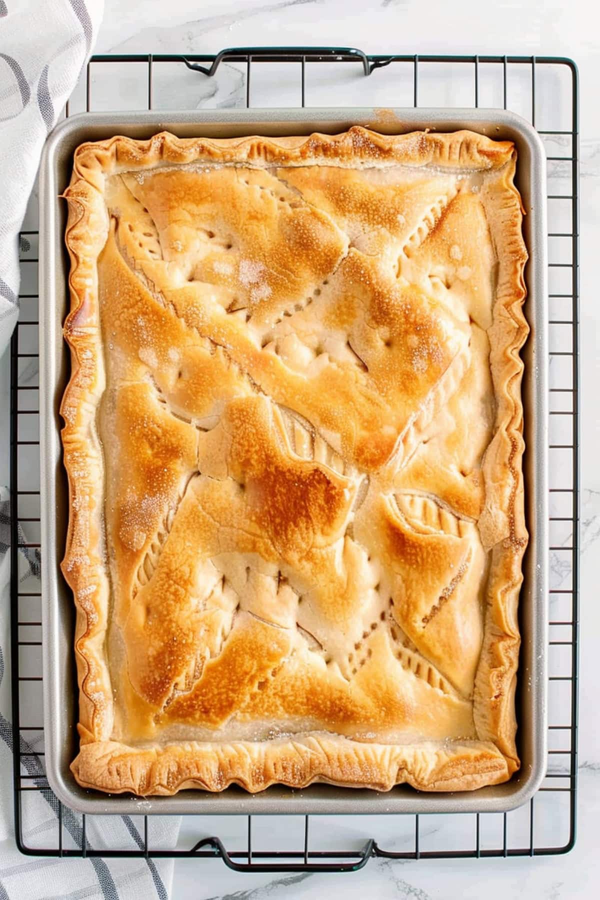 Whole apple pie slab in a baking sheet. 