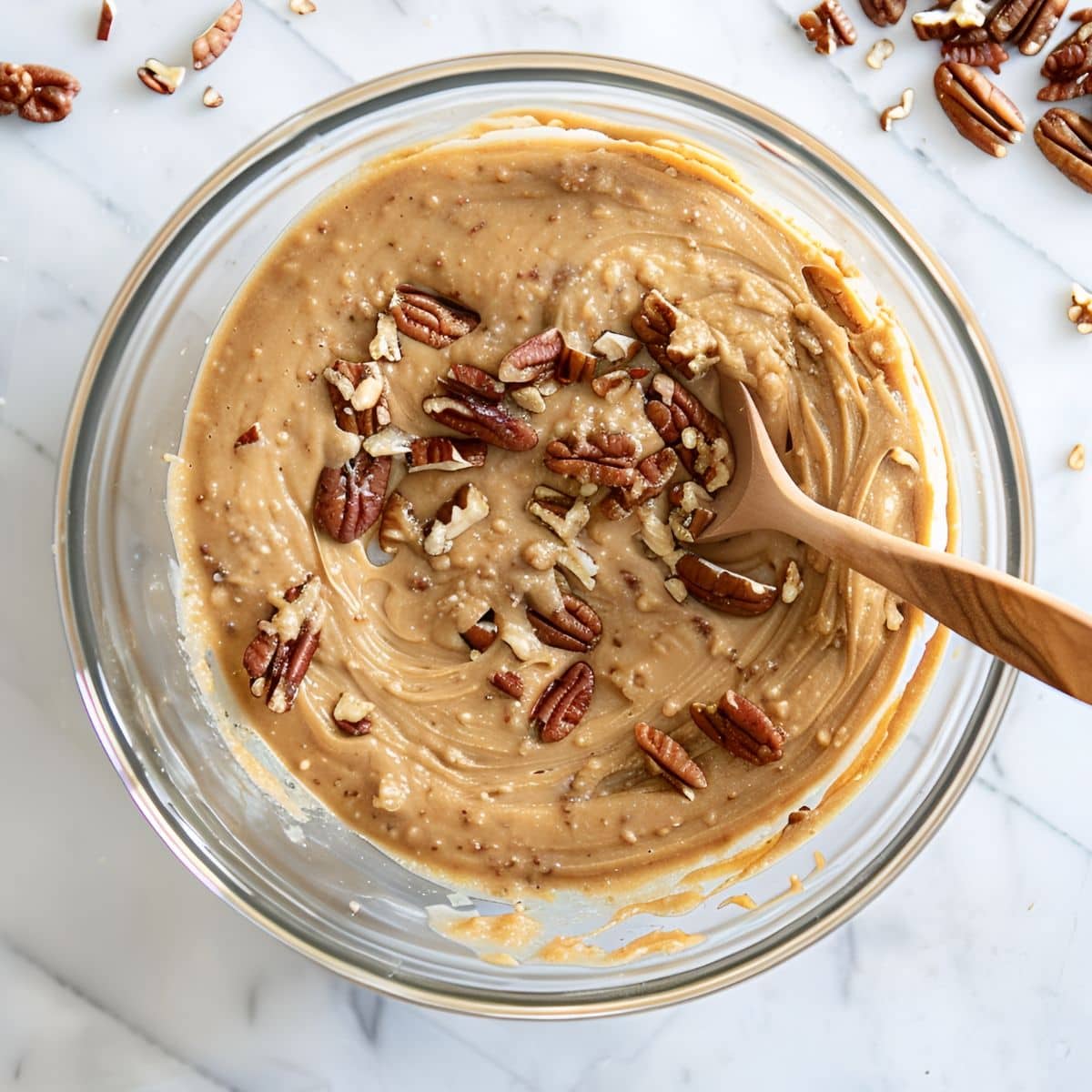 Bacardi Rum Cake in a Glass bowl with Chopped Pecans and a Wooden Spoon