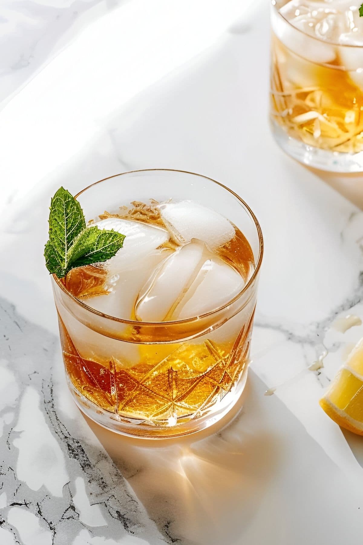 Bourbon Smash in Rocks Glass with Ice Cubes and a Spring of Mint