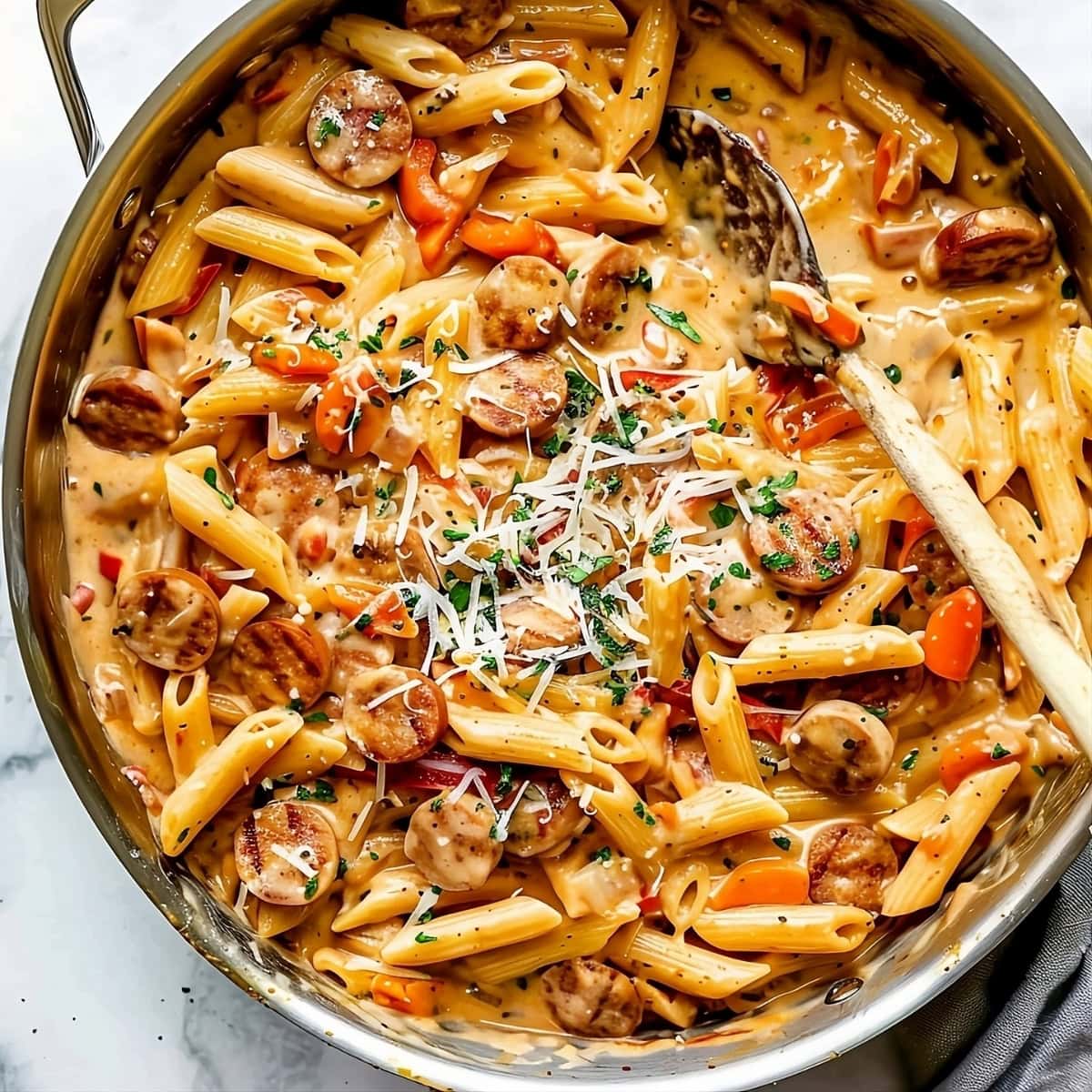 Cajun sausage pasta tossed in a skillet pan.