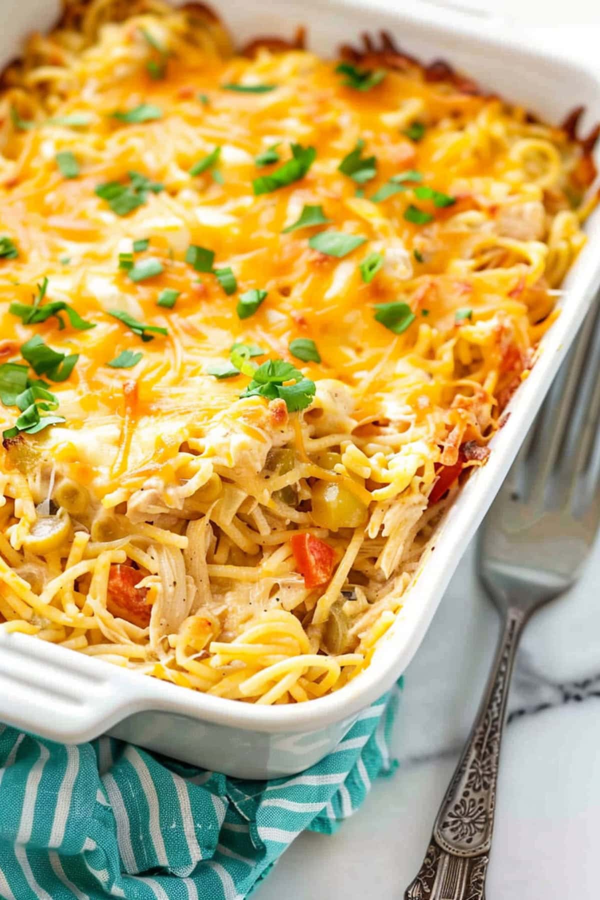 Baked cheesy chicken spaghetti casserole in a baking dish.