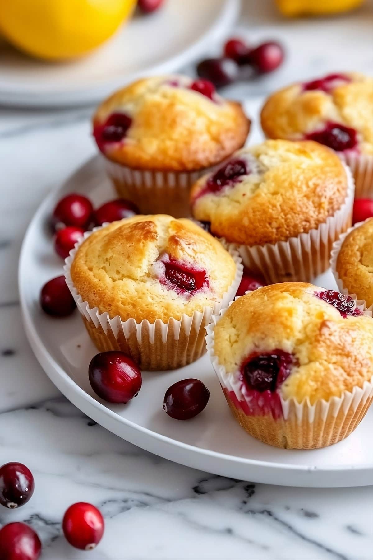Lemon cranberry muffins in a white plate.