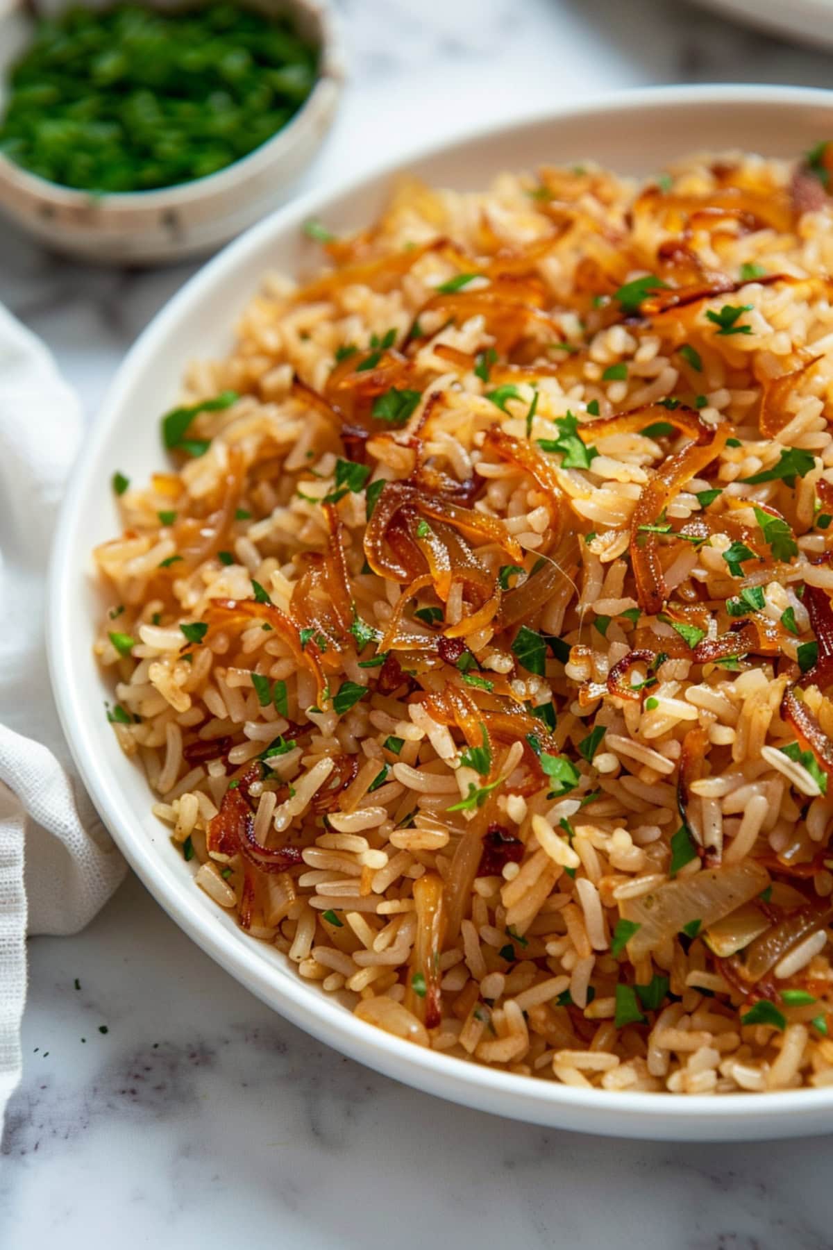 French onion rice in a white plate with chopped parsley.