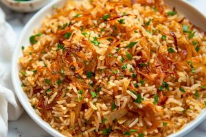 Bowl with French onion rice garnished with chopped parsley.