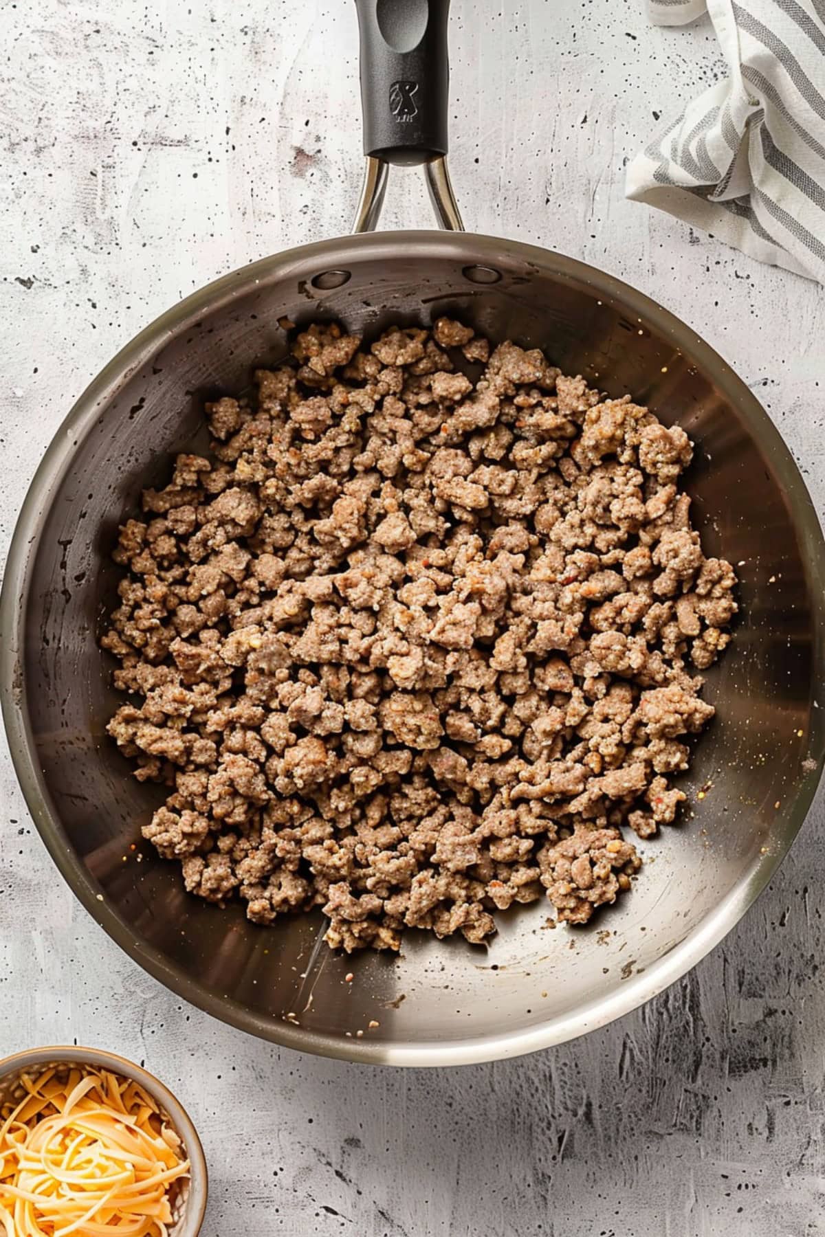 Overhead view of ground sausage with cheese on the side