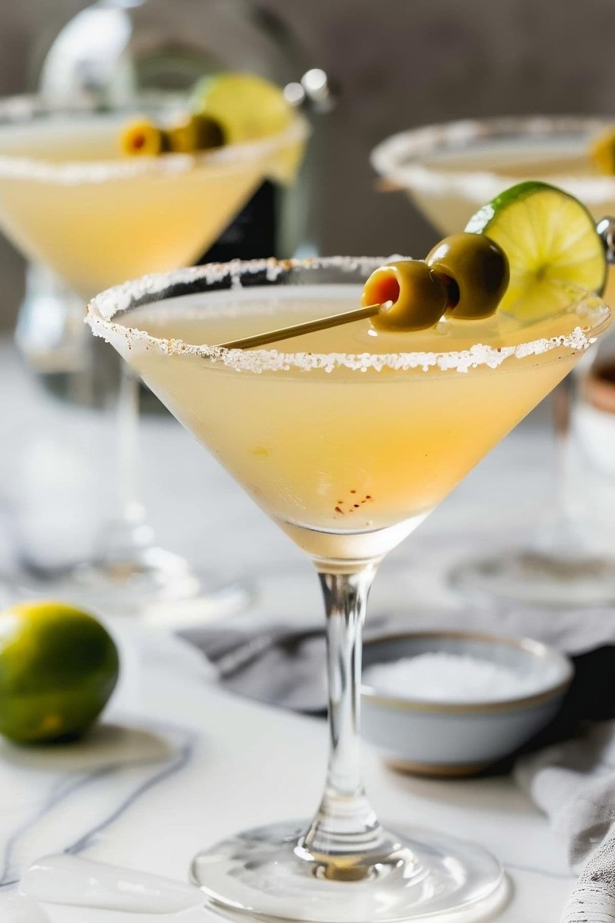 Close Up Mexican Martini with a Salt Rim, Olives and a Lime Wheel for Garnish