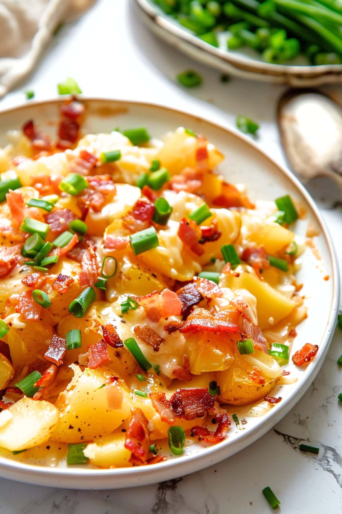 Cheesy Missisippi mud potatoes in a white plate with bacon and scallions