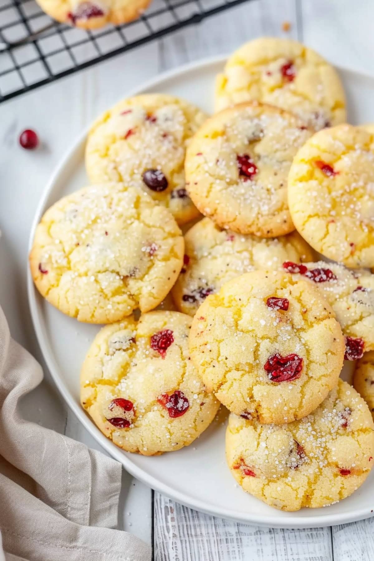 Bunch of cookies with cranberries on a white on a white wooden table.
