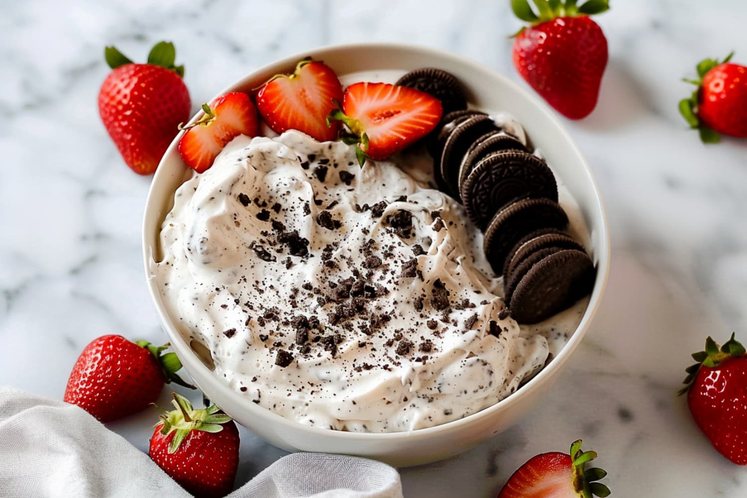 Oreo dip served in a festive bowl, topped with crushed cookies and fresh strawberries