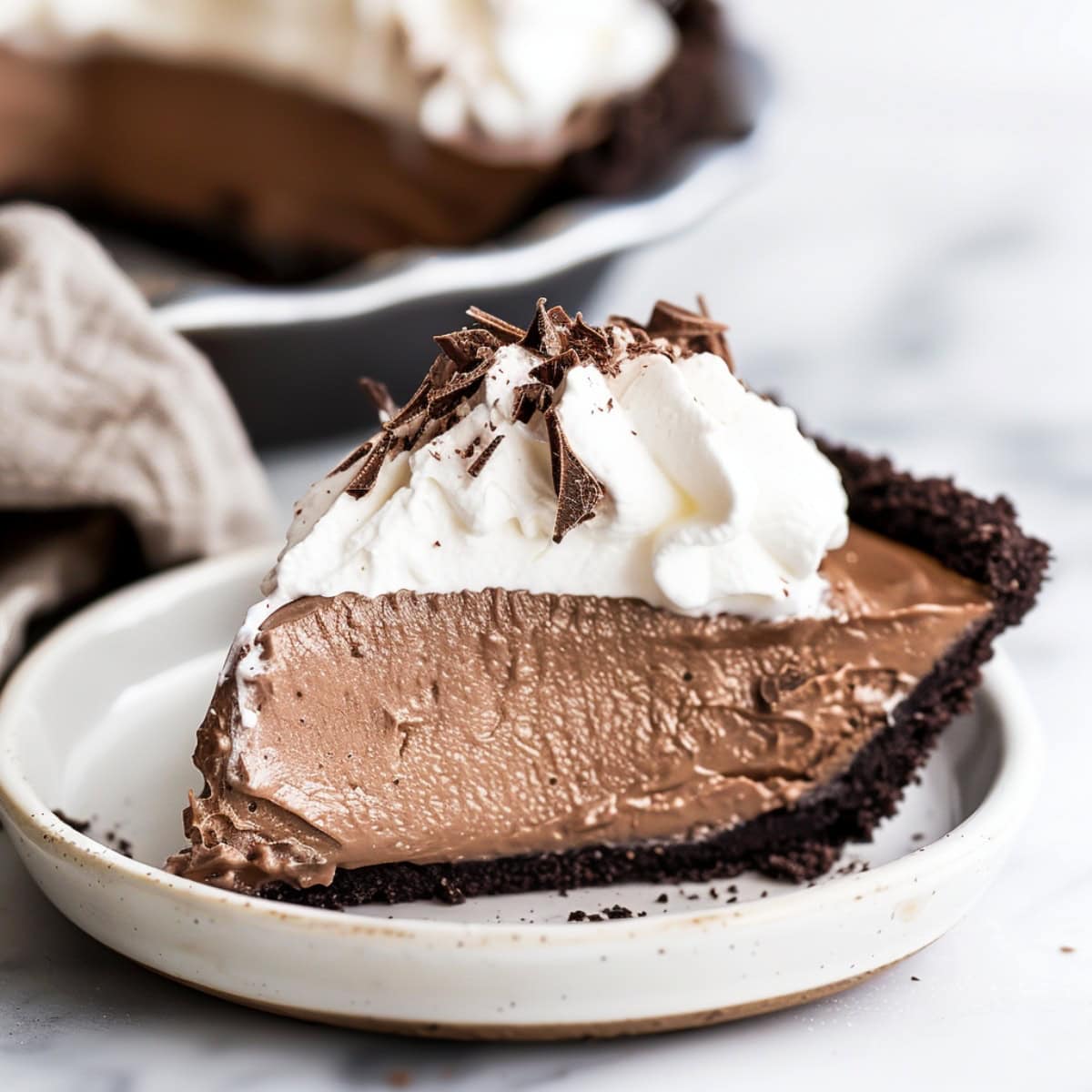 French silk pie with a Oreo crust and a smooth, glossy chocolate filling.