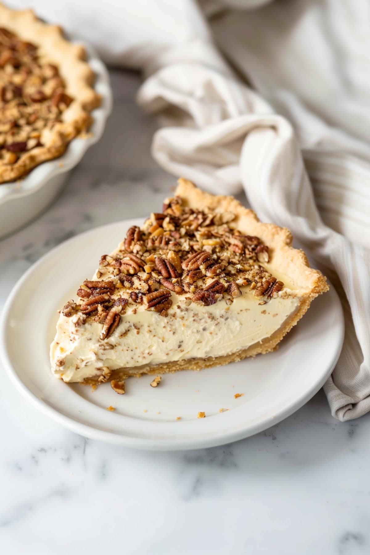 Slice of creamy homemade pecan cream pie topped with crushed nuts