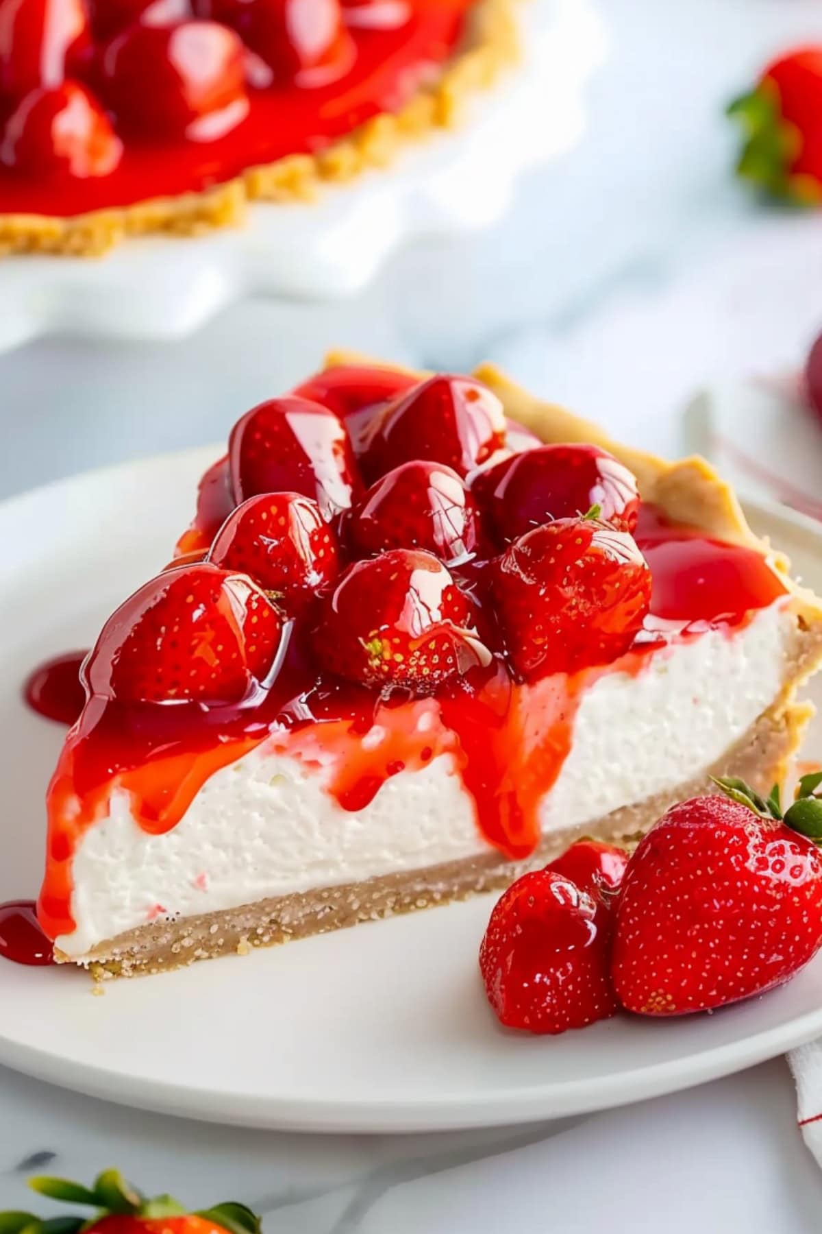 Slice of strawberry cream pie covered with strawberry glaze on top.