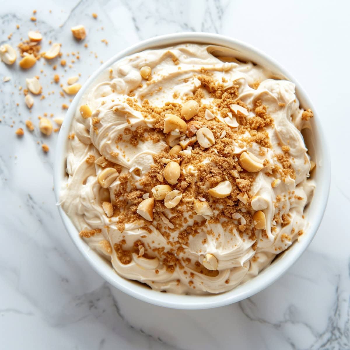 Top view of creamy peanut butter dip in a white bowl.