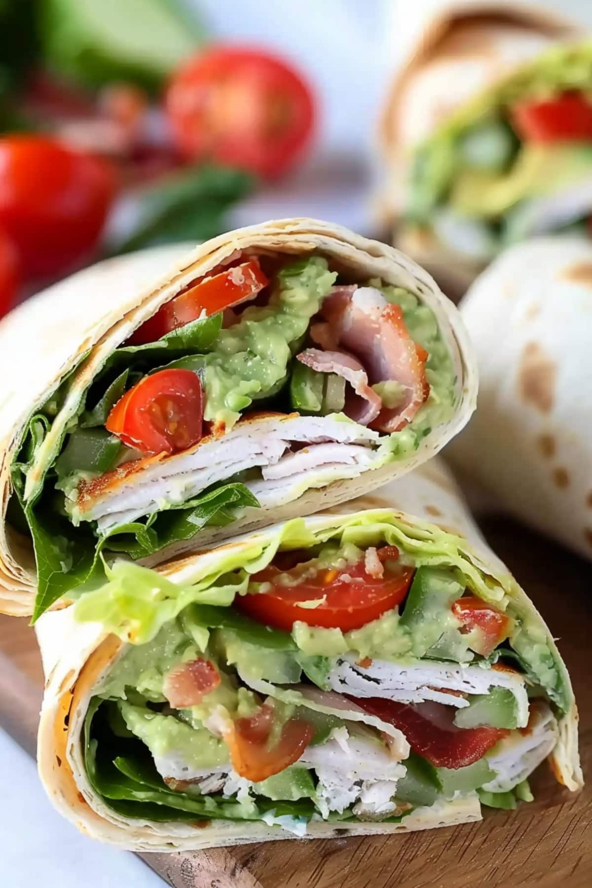 Turkey avocado wraps arranged in wooden board.