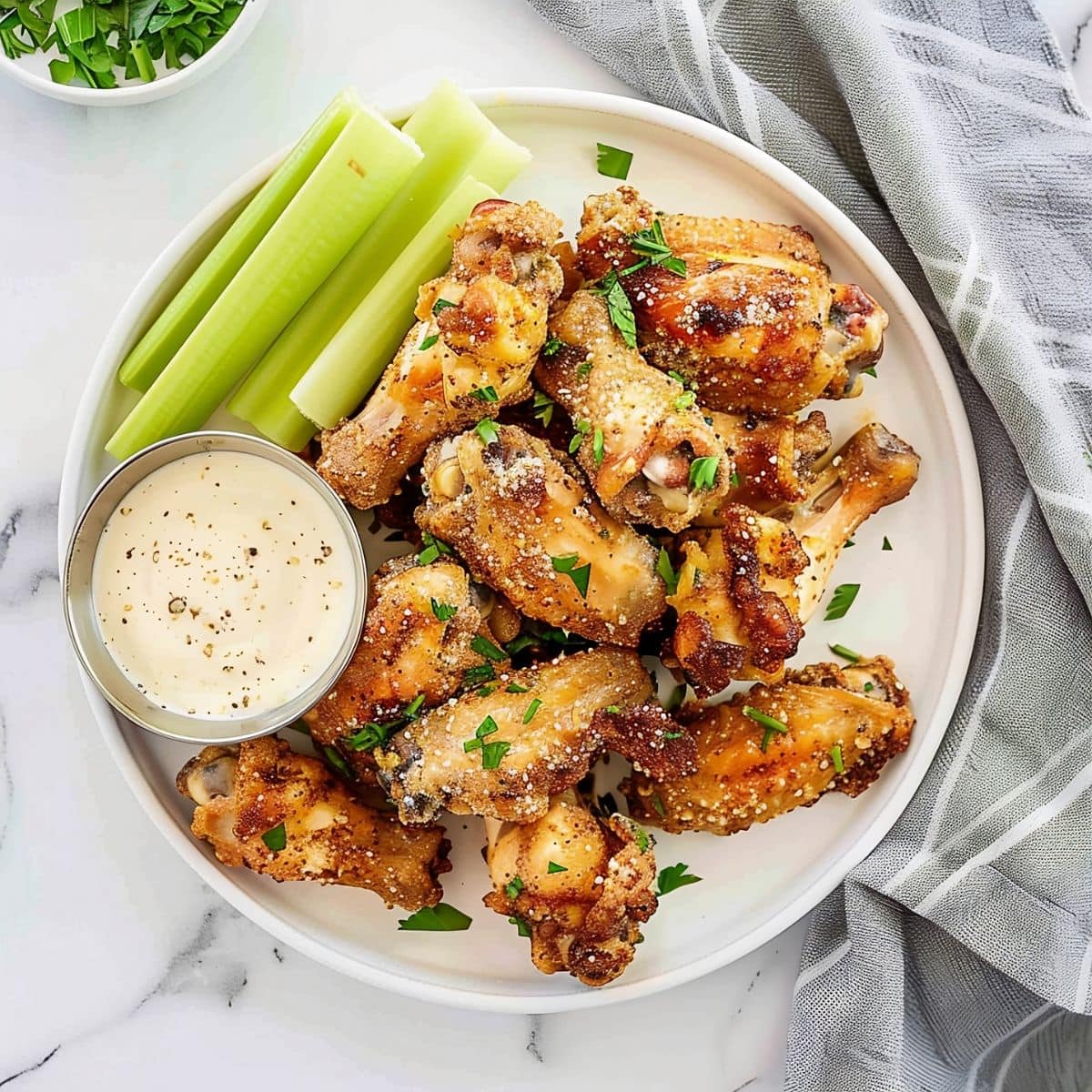 Pile of Wingstop Garlic Parmesan Wings on a Plate with Celery and Ranch Dip 