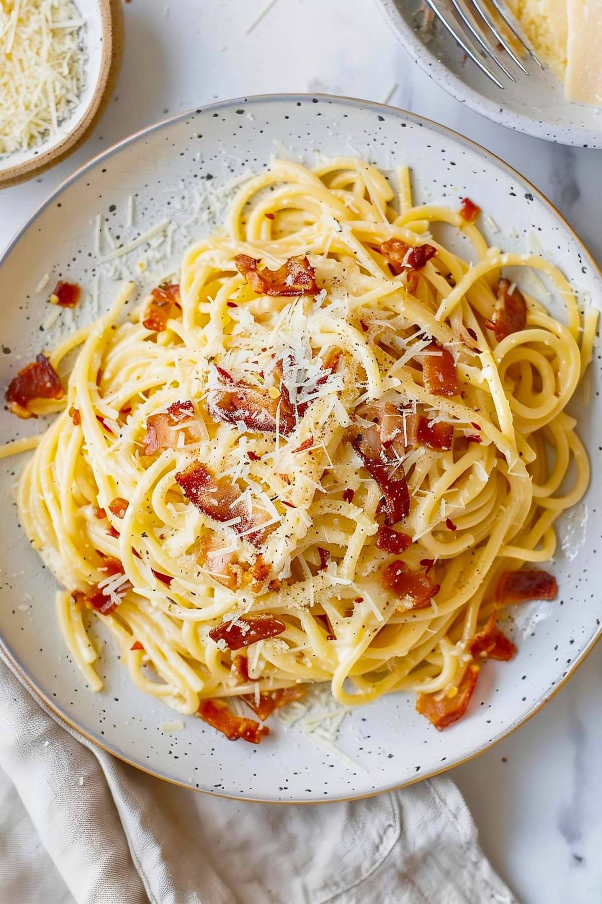 Close Up Top View of Plate of Pasta Carbonara with Bacon and Parmesan on a White Plate
