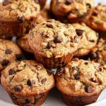 Close Up Stack of Zucchini Chocolate Chip Muffins with Chocolate Chips, Walnuts, and Pieces of Visible Zucchini