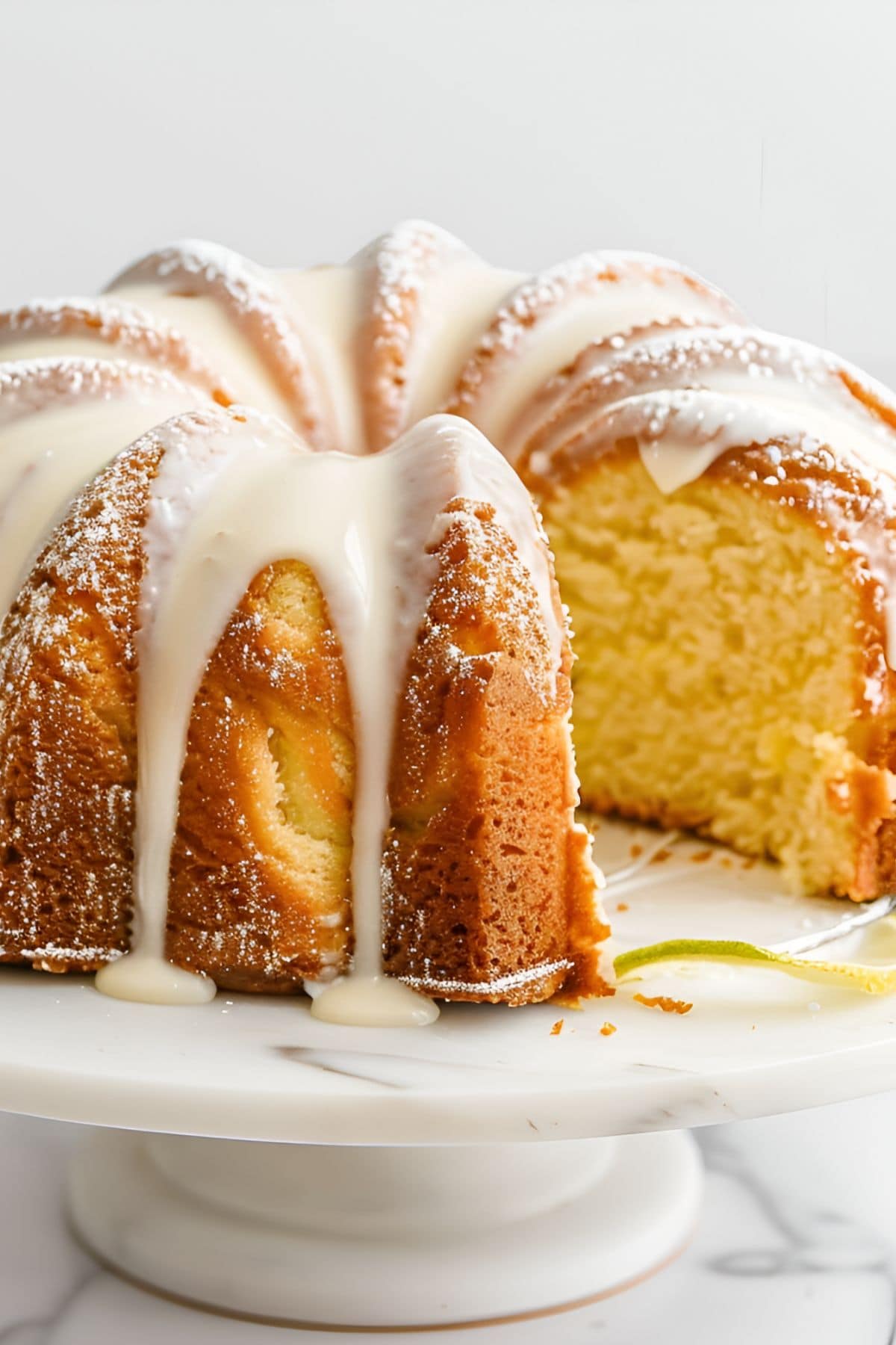 Close Up of 7-Up Cake, a Lemon Bundt Cake with Icing on a White Cake Stand