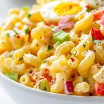 Amish Macaroni Salad Close Up in a Bowl with Noodles, Veggies, Sauce, and Hard Boiled Egg