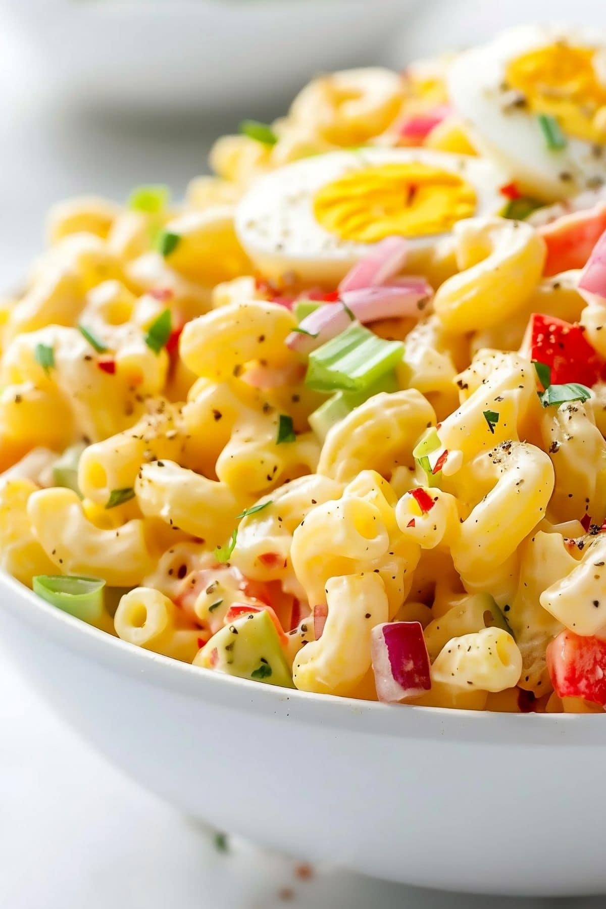 Super Close Up of Amish Macaroni Salad with Noodles, Sauce, Celery, Red Onion, Peppers, and Hard Boiled Egg