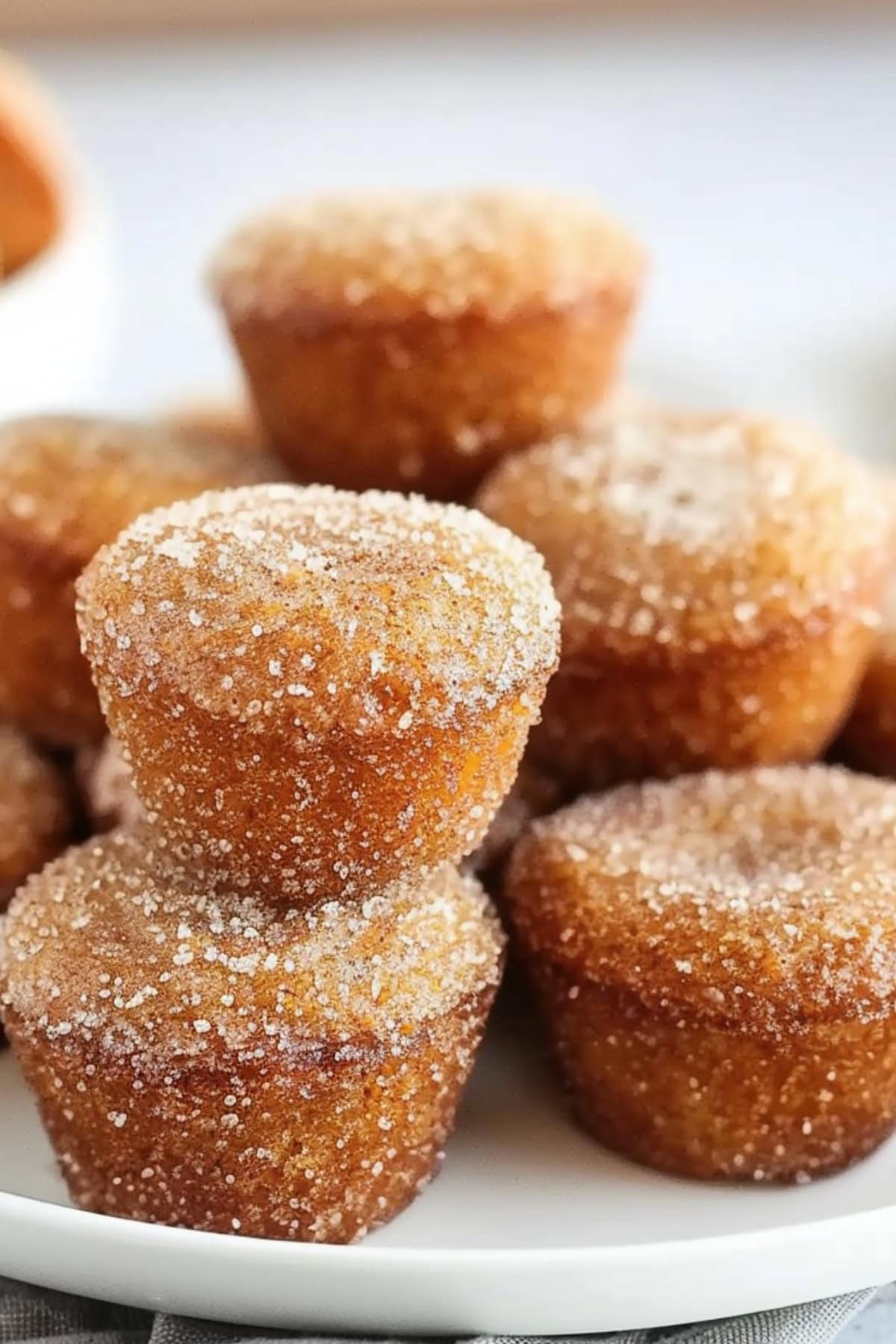 Bunch of apple cider donut muffins in a white plate. 