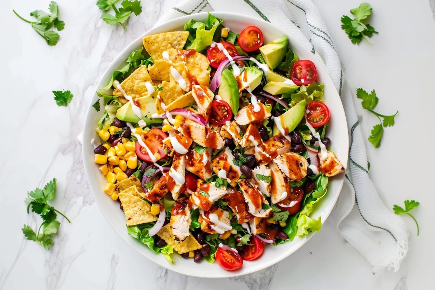 Colorful BBQ chicken salad featuring grilled chicken, black beans, corn, avocado, and cherry tomatoes on a bed of lettuce.