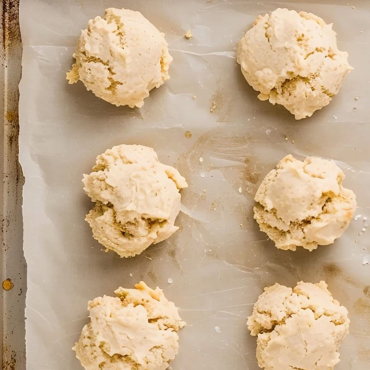 Top View of Bisquick Drop Biscuit Batter on a Parchment-Lined Baking Sheet Before Baking 