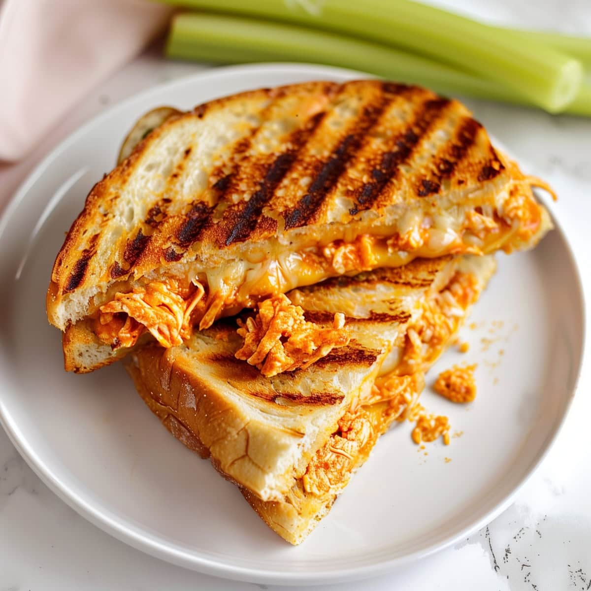 Tasty panini sandwich, featuring grilled chicken, buffalo sauce, and a blend of cheeses.