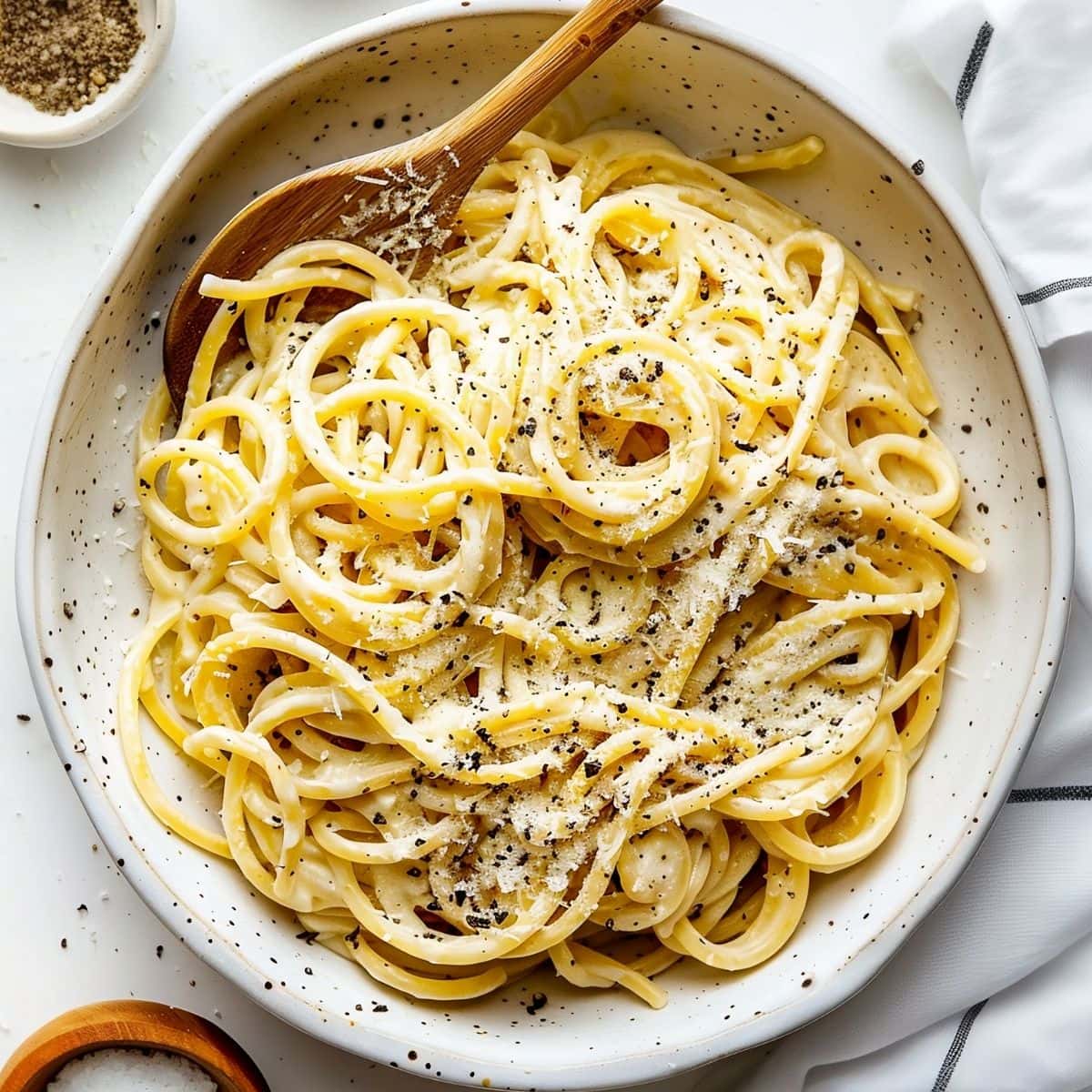 Top View of Cacio e Pepe in a Serving Dish with a Wooden Spoon