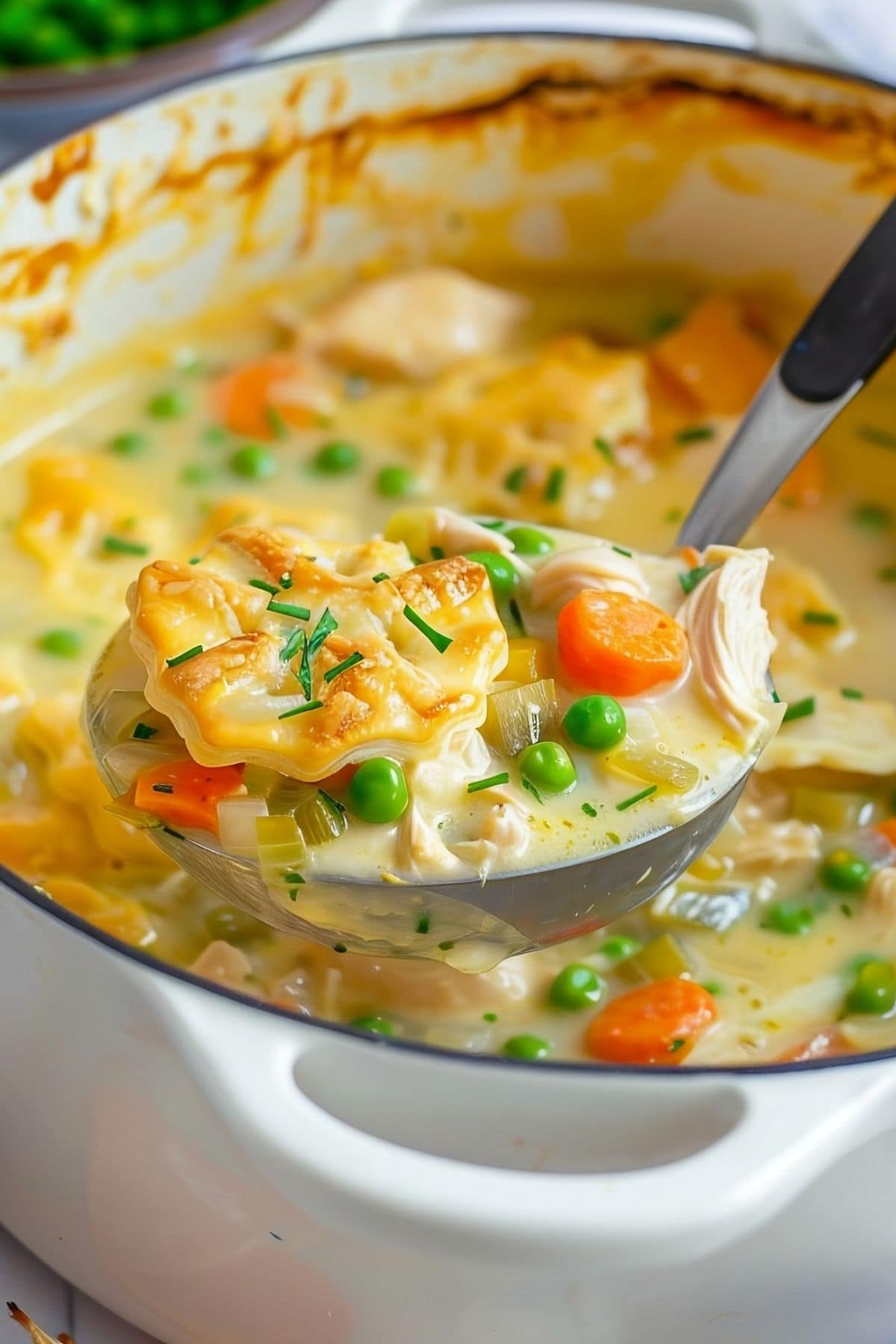 Ladle of Chicken Pot Pie Soup over a Dutch Oven of More Soup