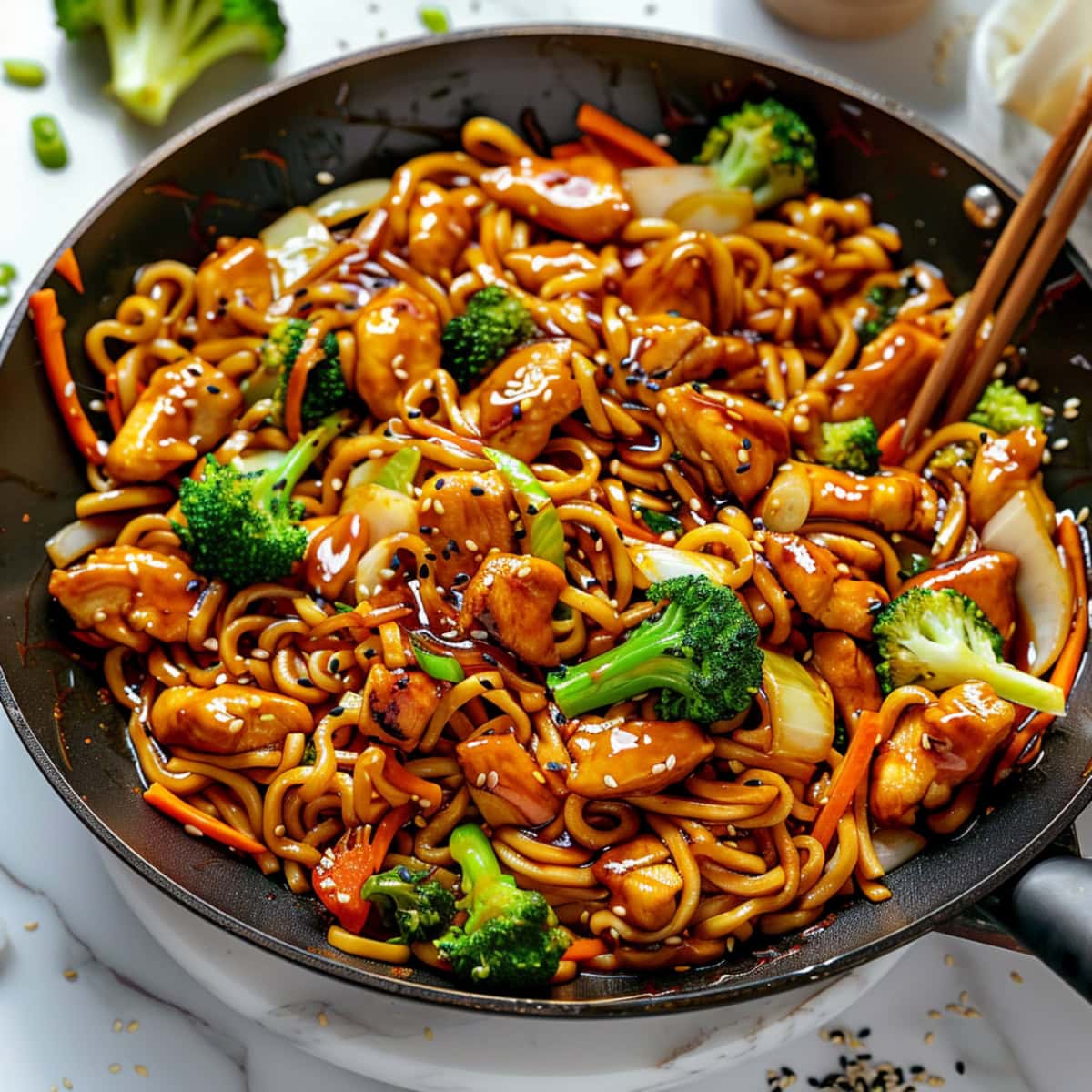 Chicken teriyaki noodles tossed in a wok.