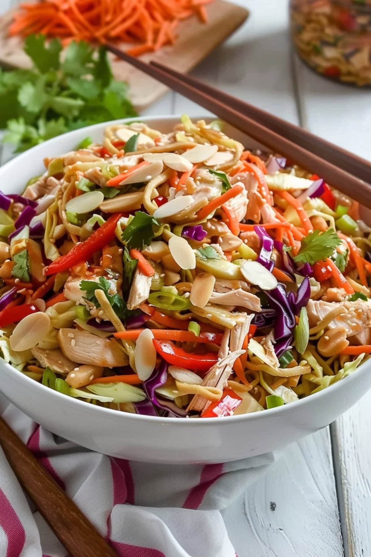 Bowl of Chinese chicken salad with wooden chopsticks on top.