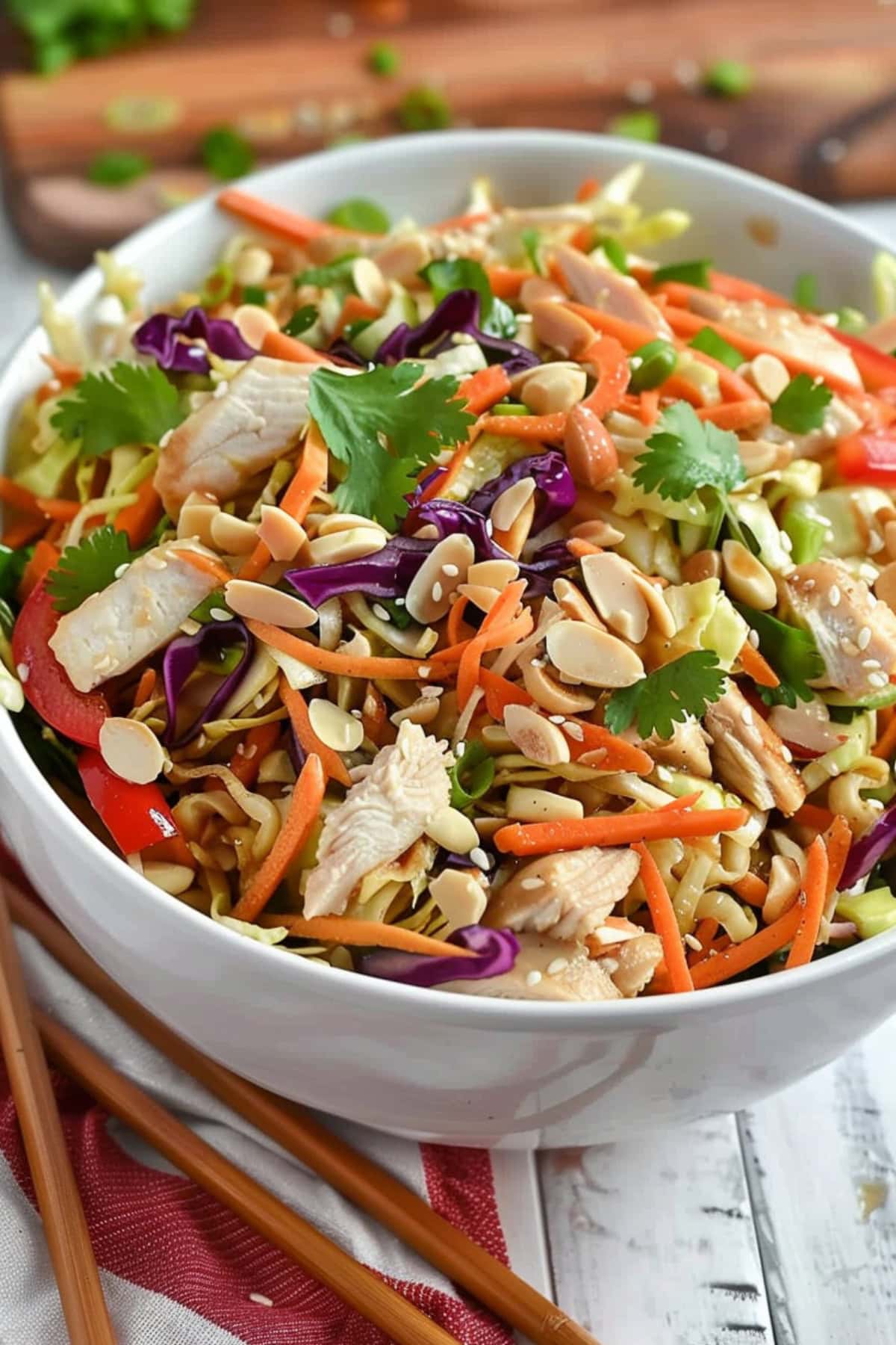 Salad made of chow mien noodles, almond slices, carrots, bell peppers, napa cabbage and cilantro.