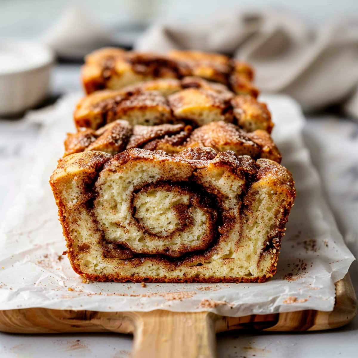 Moist homemade cinnamon swirl quick bread in a wooden board.