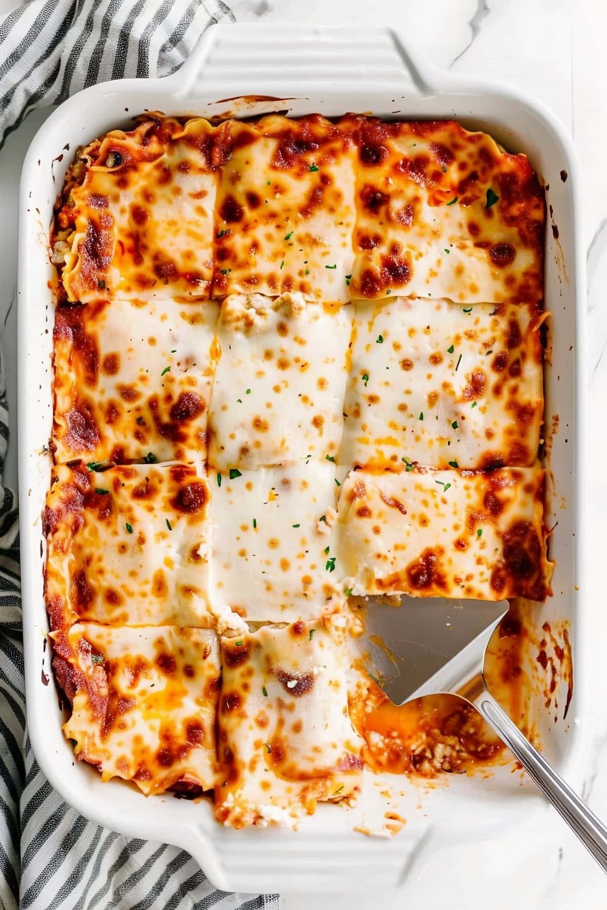 Top View of Cottage Cheese Lasagna in a Casserole Dish with a Spatula