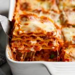 Spatula Pulling a Slice of Cheesy, Saucy Cottage Cheese Lasagna out of a Casserole Dish of Lasagna