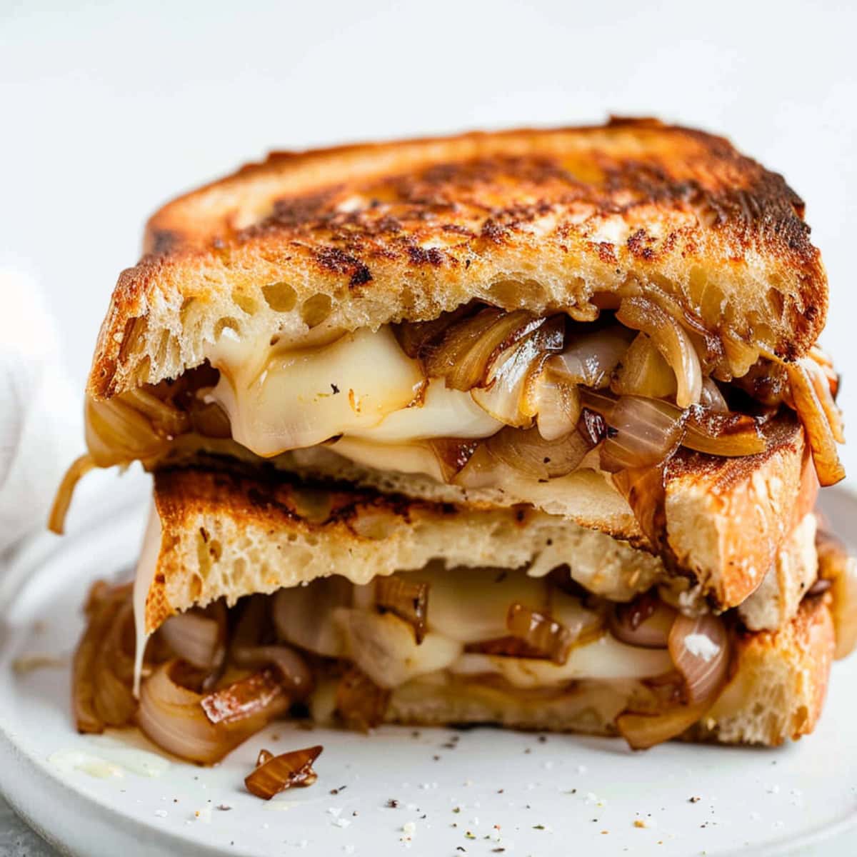 Sliced in half French onion grilled sandwich with melted cheese.
