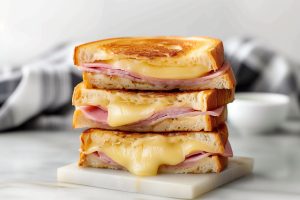 A stack of savory and cheesy grilled ham and cheese sandwich featuring a nutty melted Gruyère.