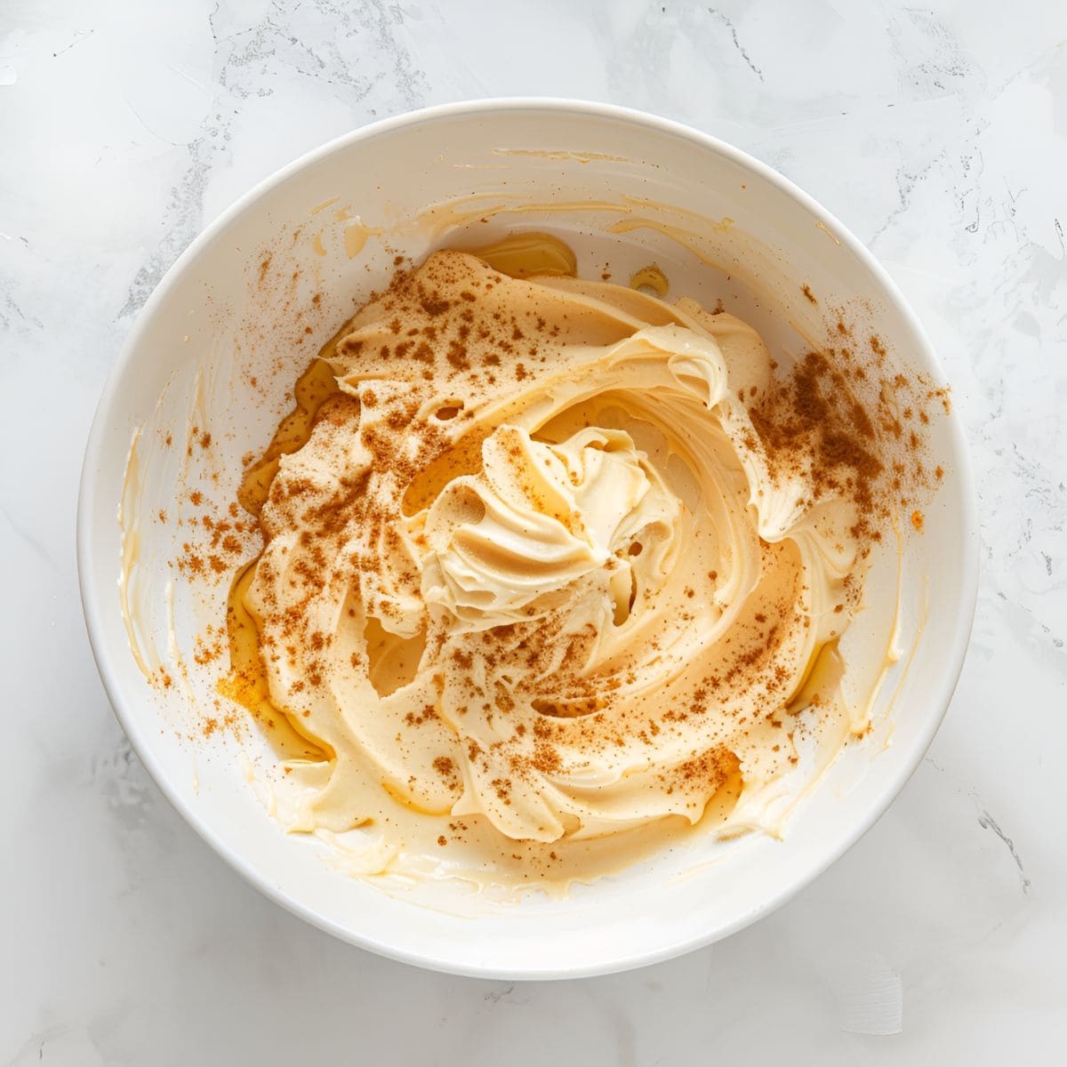 Top View of Hot Buttered Rum Batter in a Bowl with Butter and Cinnamon