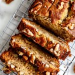 Top View of Ina Garten's Banana Bread Loaf, Sliced, with Toasted Pecans on a Wire Rack