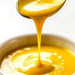 Close Up of McDonald's Hot Mustard Sauce Dripping Off a Spoon into a Ramekin of More Mustard Sauce