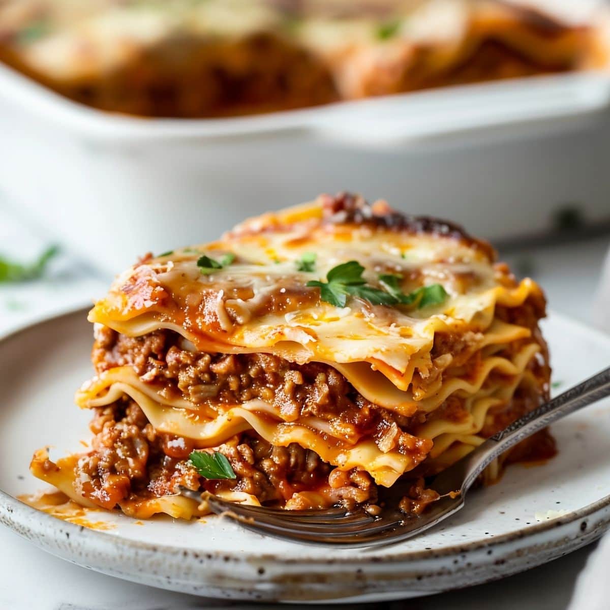 Slice of Prego Lasagna- Layers of Noodles, Meat Sauce, and Melty Cheese- on a Plate with a Fork