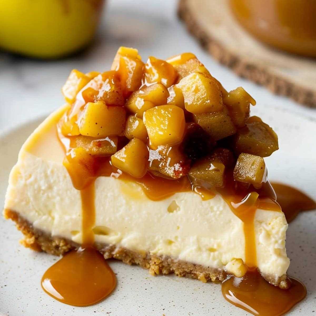 A slice of caramel apple cheesecake showing the rich, creamy layers and sweet fruit topping.