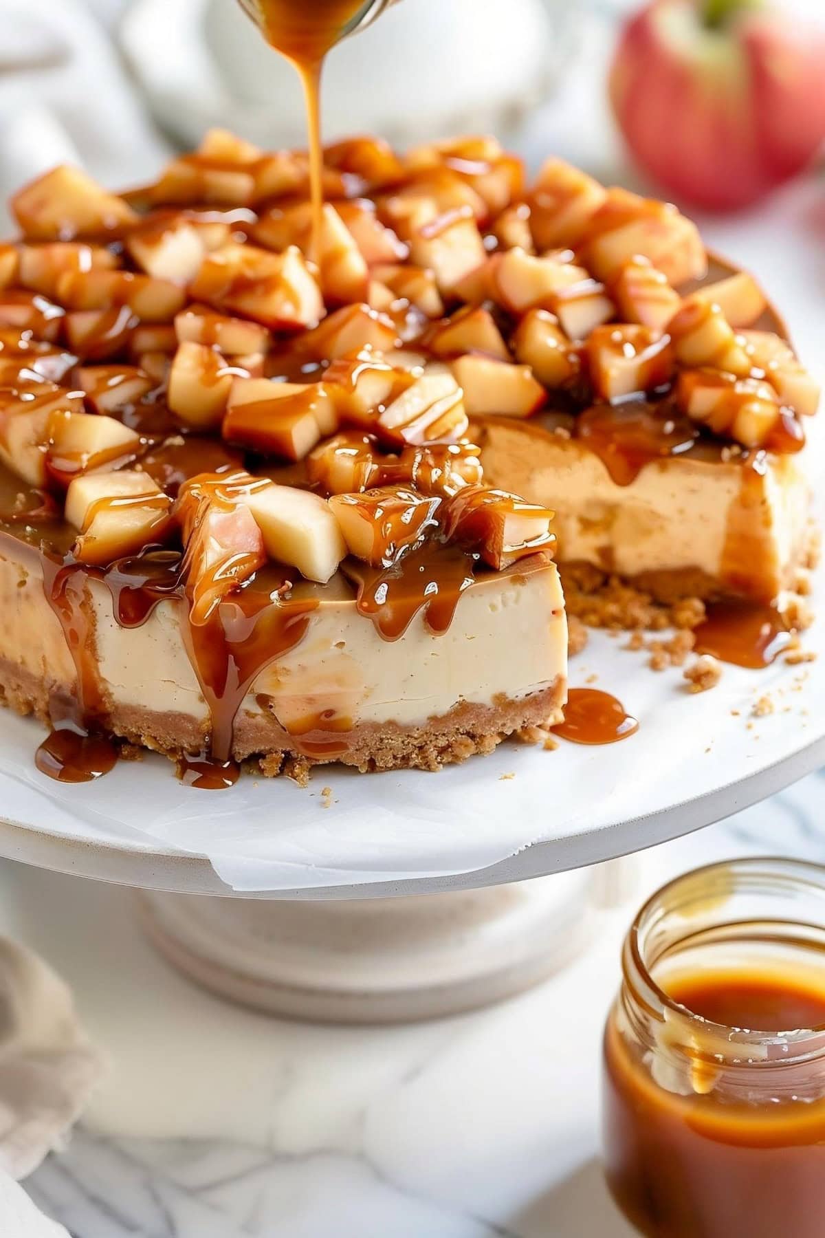 Homemade caramel apple cheesecake with caramel drizzled over the top