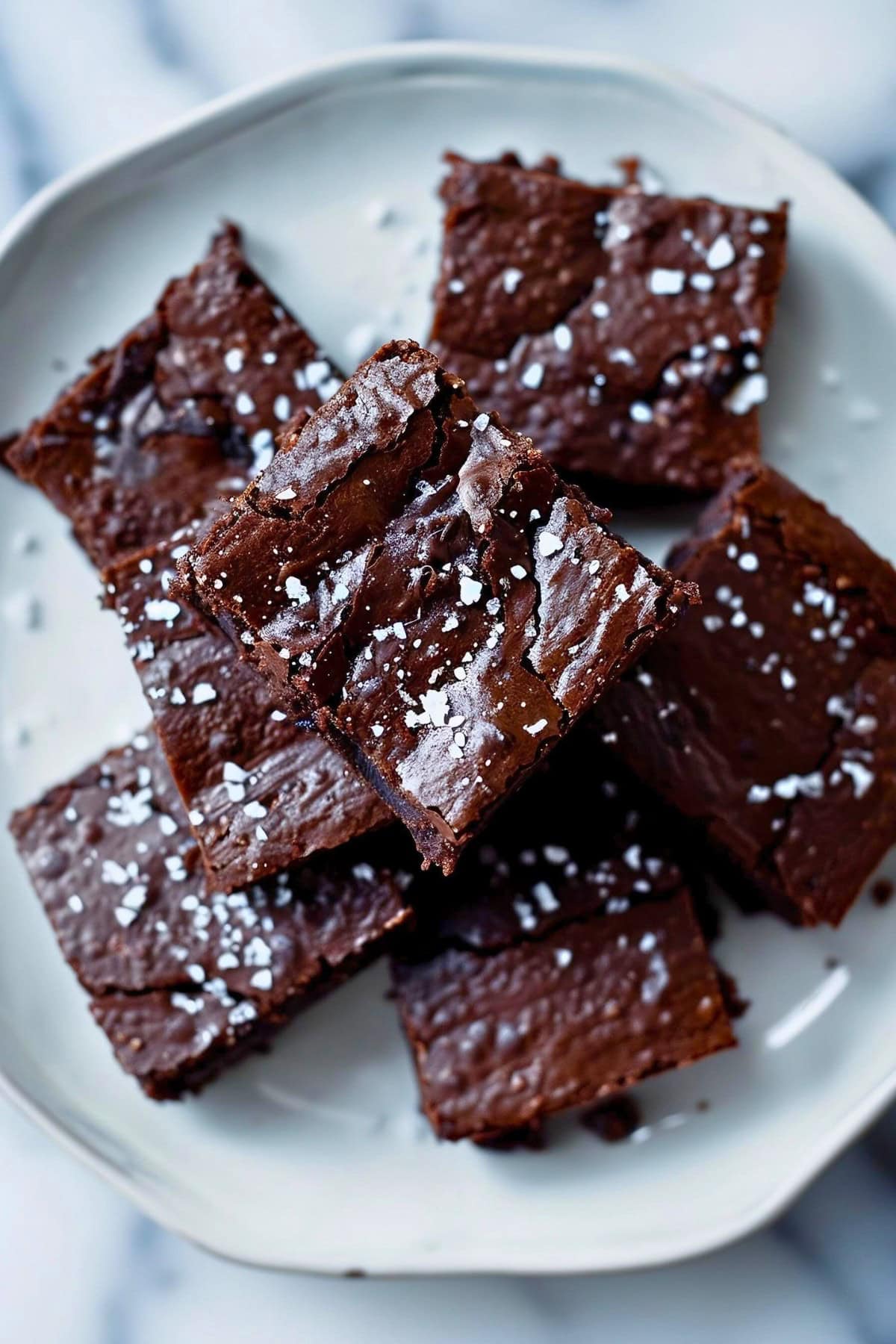 Close Top View of a Pile of Chocolate Brownies with Sea Salt on a Plate