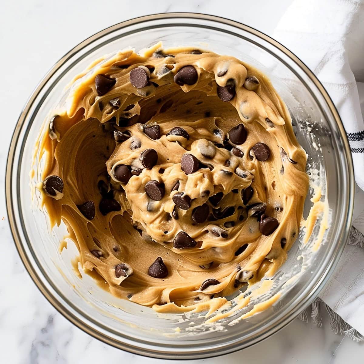 Chocolate chip cookie dough in a glass bowl.