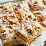 Slice of White Texas Sheet Cake with Pecans on a Spatula