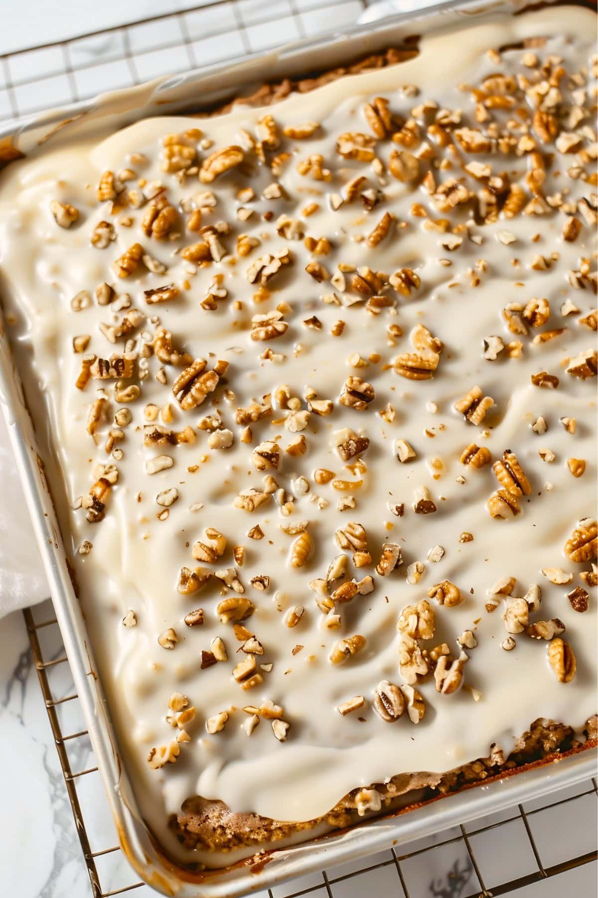 Close Top View of White Texas Sheet Cake in a Sheet Pan Cooling on a Wire Rack